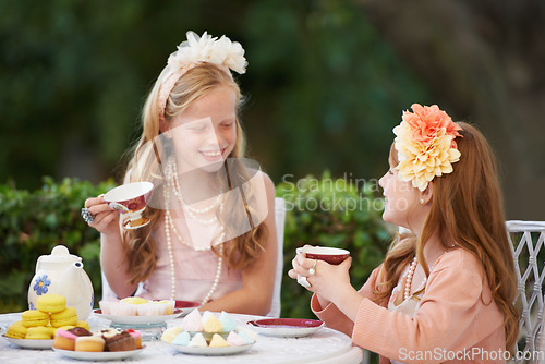 Image of Tea, party and girl children are happy outdoor, playing with fine china for celebration and fun in backyard. Relax, spring and kids in garden together, friends with beverage or drink for bonding