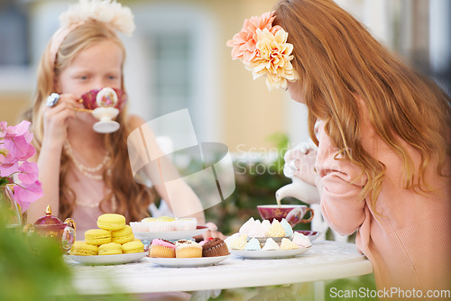 Image of Girls, children and friends at tea party in nature for fantasy play for cake, birthday or game. Kids, food and fancy dress up or flower crown or outdoor for summer bonding, backyard or macarons