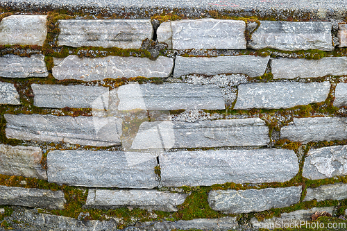 Image of Close-Up View of an Old Stone Wall With Green Moss Growth in Day