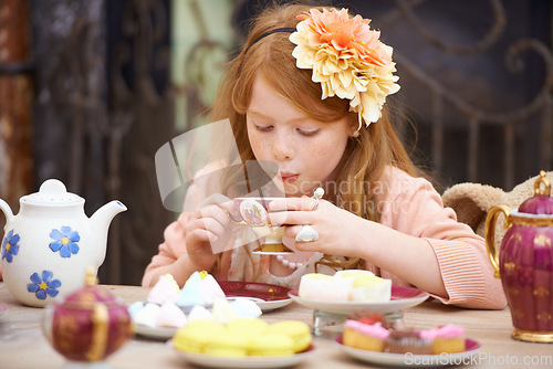 Image of Girl, child and drinking tea in garden with party for birthday, celebration and playing outdoor in home. Person, kid and porcelain cup in backyard of house with dress up, beverage and role play fun