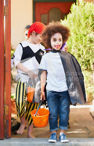 Image of Children, halloween and trick or treat outdoor in costume for celebrate, holiday and spooky outfit or tradition. Kids, event and autumn role play with basket, fancy dress or happy in garden of home