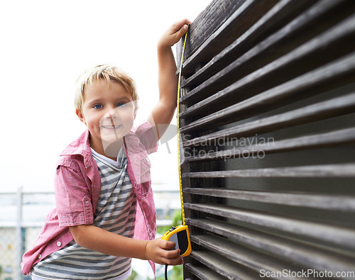 Image of Smile, measuring tape and portrait child doing maintenance on wood gate for fun or learning. Happy, equipment and young boy kid working on repairs with tool for home improvement outdoor at house.