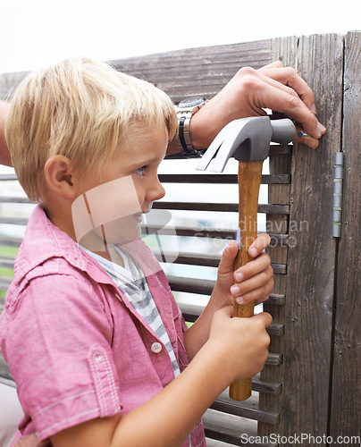 Image of Happy, hammer and boy kid doing maintenance on wood gate for fun or learning. Smile, equipment and young child looking and working on repairs with tool for home improvement outdoor at modern house.