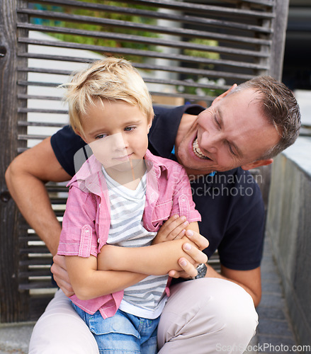 Image of Laughing, happy and father tickling child for bonding together in backyard at family home. Smile, annoyed and dad playing and having fun with bored boy kid by wood gate for quality time outdoor house