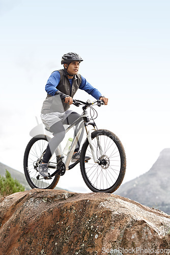 Image of Sports, athlete and a man on a bike on the mountain for cycling, training and travel in nature. Idea, health and a male cyclist on a hill with a bicycle for riding, exercise and an outdoor workout