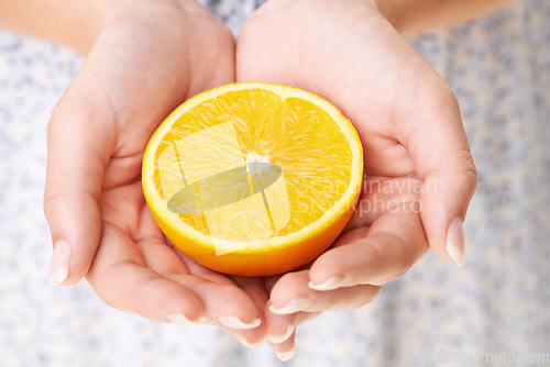 Image of Health, hands and closeup of woman with orange in studio for detox, vegan diet and fresh ingredient. Wellness, nutrition and zoom of female model with organic fruit or produce for vitamin c benefits.