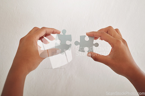 Image of Hands, studio or puzzle for problem solving, solution or innovation on white background. Development project, mission or closeup of person for answer, jigsaw strategy or creative brainstorming plan