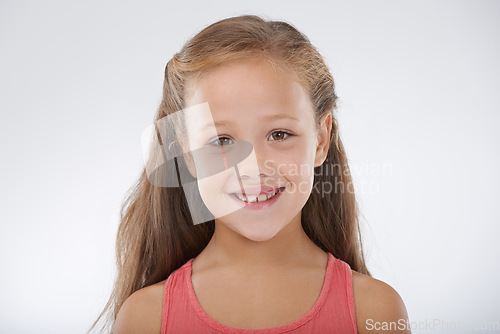 Image of Child, girl and portrait or happiness in studio with confidence, positive attitude and carefree youth. Kid, face and smile with calm expression, mock up space and casual outfit on white background