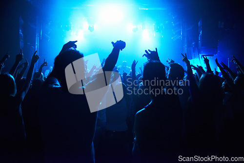 Image of Nightclub, people and crowd with energy and lights for party, concert or rave festival with spotlight and dancing. Disco, psychedelic event and performance with entertainment, audience and rear view