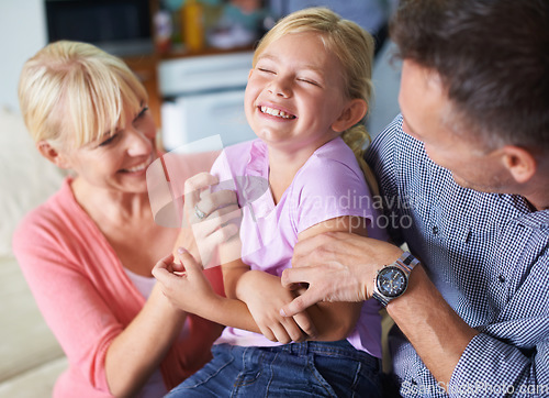 Image of Girl, parents and tickle for fun at home, security and love in childhood or happiness. Family, daughter and child playing games on vacation, smiling and connection or care in relationship on holiday