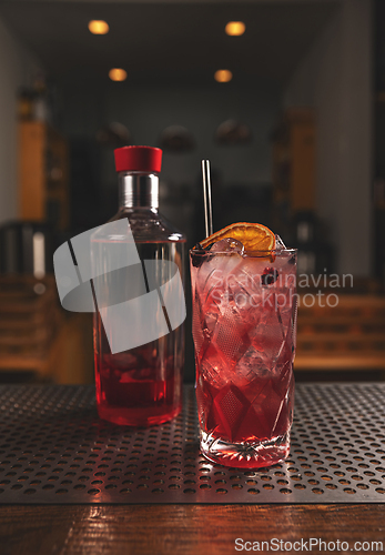 Image of Red cocktail decorated with orange slice