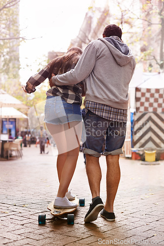 Image of Skateboard, ride and couple of friends teaching partner sports skills, exercise lesson or training in urban Paris. Skate, back and learning skateboarder helping, coaching and support balance of rider