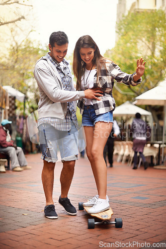 Image of Skateboard ride, happy and couple teaching girlfriend how to balance, exercise lesson or training in urban Spain. Skate, fun and skateboarder helping, coaching and smile for skateboarding development