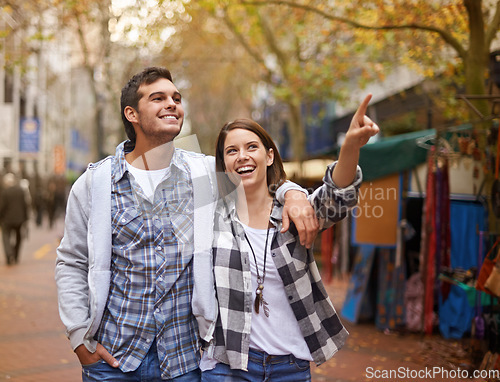 Image of Happy, walking and couple pointing at city destination, morning trip and tour of urban Paris for outdoor adventure. Love, travel and bonding man, woman or relax people gesture at street view