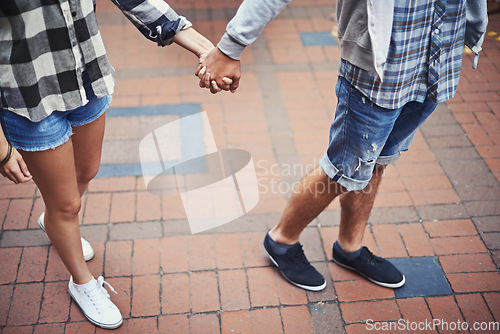 Image of Legs, walking and couple holding hands on relax journey, morning trip and weekend tour for outdoor adventure. Love, ground and romantic people commute together on street, road or sidewalk floor