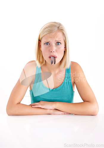 Image of Confused, woman and portrait of eating fish, tail or strange food in mouth on white background of studio. Crazy, diet and person with weird seafood, cuisine or disgust for taste of tuna or salmon