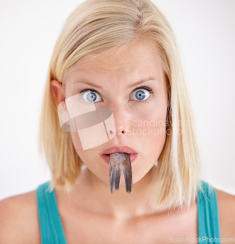 Image of Portrait, woman and eating tail of fish with surprise and shock on white background of studio. Crazy, diet and person with taste of weird seafood, cuisine and disgust for gross or strange food