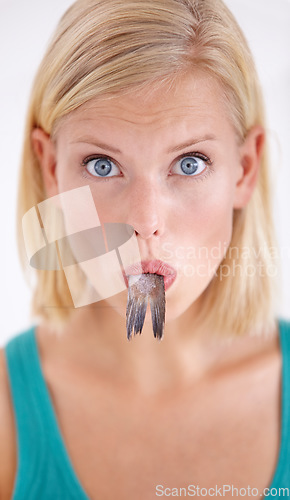 Image of Eating, fish and portrait of woman with surprise and tail in mouth on white background of studio. Crazy, diet and hungry person with weird cuisine and seafood for sushil, nutrition and shocked face