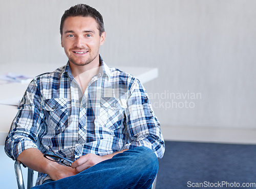 Image of Chair, entrepreneur or portrait of happy man with smile, small business or confidence in office. Sitting, male designer or employee with pride at startup job, career or company alone by mockup space