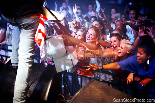 Image of Music festival, stage and fans of musician at performance, event and excited screaming for rockstar. Concert, crowd and people in audience stretching and listening to artist in band with freedom