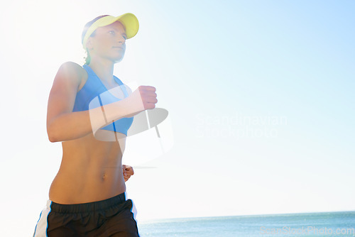 Image of Fitness, beach and young woman running for race, competition or marathon training exercise. Sports, health and female athlete runner with cardio workout for endurance and speed by ocean or sea.