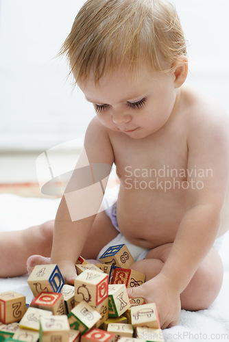 Image of Fun, kid and baby with his learning cubes, happiness or smile with joy, peaceful and education. Growth, cheerful or child development with toys, active or excited with games, wooden blocks or playing