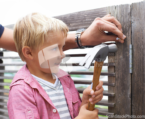 Image of Smile, hammer and young child doing maintenance on wood gate for fun or learning. Happy, equipment and cute boy kid working on repairs with tool for home improvement outdoor at modern house.