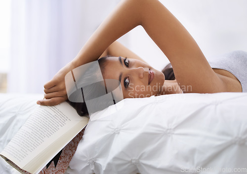 Image of Woman, bed and book portrait in the morning with reading and relax in a home with a smile. Indian female person, bedroom and wake up on duvet with peace and calm in a house on a blanket with comfort