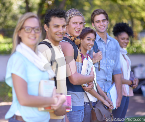 Image of Students, portrait and happy on campus, row and scholarship opportunity at university with books. Friends, face and diversity in education in learning and study group in college park with commitment