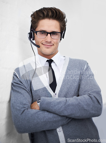 Image of Business man, call center and headphones in portrait, smile and microphone by wall background. Telemarketing employee, worker or person with mic, pride and contact us with voip for technical support