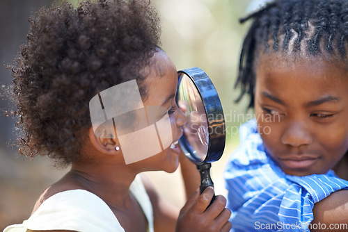 Image of Kids, nature and magnifying glass in a forest for face, inspection or discovery in search together. Black family, children and magnifier in park for adventure, learning or exploring, games or fun