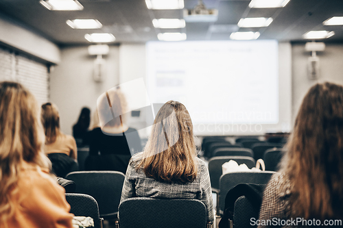 Image of Speaker giving a talk in conference hall at business event. Rear view of unrecognizable people in audience at the conference hall. Business and entrepreneurship concept.