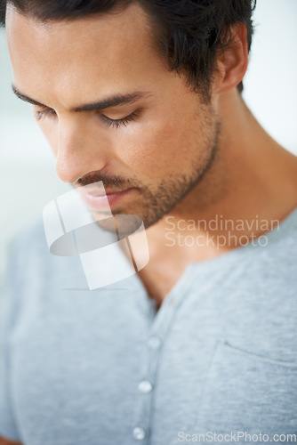 Image of Face, thinking and regret with a young man closeup on a white background for error, mistake or fail. Depression, sad or worry and a concerned young person looking down with stress or anxiety