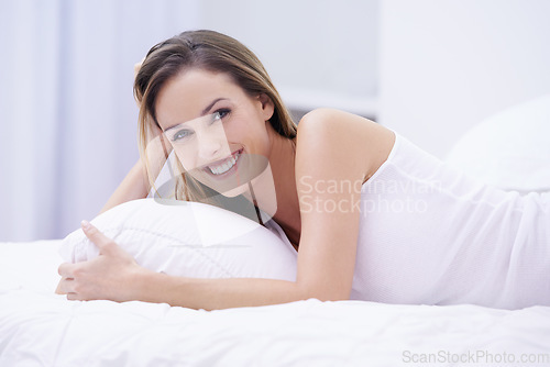 Image of Woman, happy and relaxing in bed in portrait, lazy and comfortable on morning at home. Female person, smiling and satisfaction while resting in bedroom, wake up and good mood on vacation or holiday