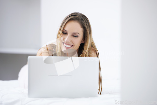 Image of Happy woman, bedroom and laptop for planning, search on website and registration or streaming at home. Young person relax on bed with computer for morning news, social media update or reading blog