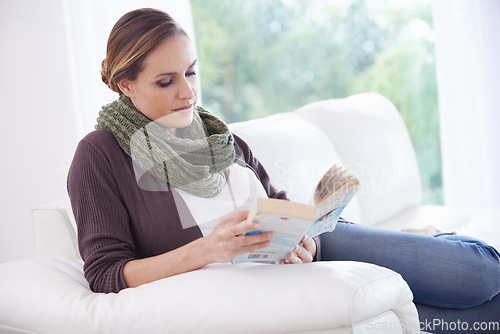 Image of Woman, book and reading on sofa to relax for story, novel and learning knowledge in living room at home. Lady, fiction books and break for studying literature, hobby or comfortable on couch in lounge