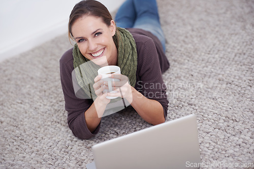 Image of Woman, laptop and relax in portrait with coffee, happy with tech and streaming online for video or movie with internet at home. Connect, film or tv show, carpet or floor for entertainment and drink