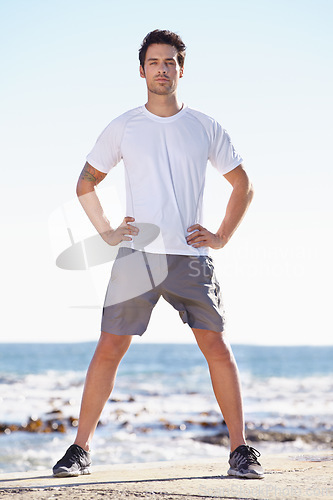 Image of Man, fitness and portrait on beach, runner outdoor for cardio and exercise, ocean and nature with athlete. Sports, running and endurance with training or workout for health and wellness with travel