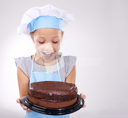 Image of Kid, baker and excited with cake, happy and confident with child development on white background. Culinary skills, satisfied and baking dessert and childhood with confidence in hospitality industry