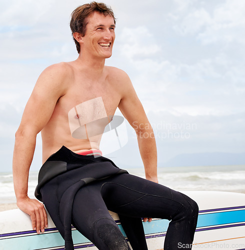 Image of Vision, smile and shirtless man with surfboard on beach in wetsuit for sports, travel or fitness. Nature, thinking and body of young surfer on sand by ocean or sea for exercise, training and workout