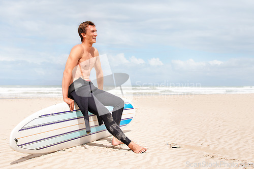 Image of Thinking, beach and shirtless man with surfboard on space in wetsuit for sports, travel or fitness. Nature, vision and body of young surfer laughing with sand by ocean for exercise on blue sky