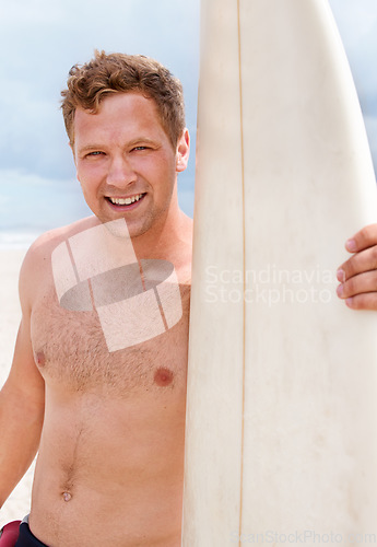 Image of Portrait, happy and shirtless man with surfboard at beach on blue sky for sports, travel or fitness. Nature, smile and body of young person by ocean or sea for surfing, exercise and training