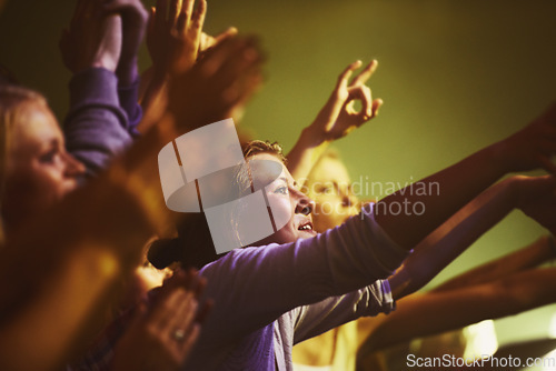 Image of Concert, fans and dance to music at night,, performance and audience with energy at festival. Crowd, support and people stretching hands in celebration or praise of rock, culture or excited at event