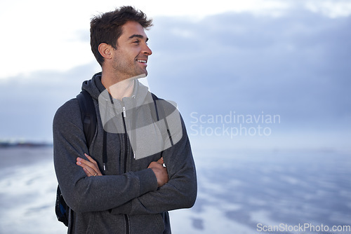 Image of Thinking, beach and man with arms crossed, travel and backpack with holiday, idea or getaway trip. Person, seaside or traveller with nature or wellness with water, explore or smile with summer break