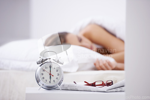 Image of Sleeping, morning and woman in bed with alarm for snooze, wake up and start day in home. Lazy, tired and person resting, dreaming and relaxing in bedroom with time, clock and glasses in house