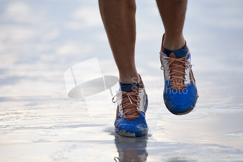 Image of Water, running and feet outdoor for fitness, sports and training in nature closeup. Legs, zoom and sneakers of person at the ocean for exercise, workout or morning cardio, marathon or seaside workout