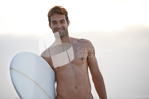 Image of Fitness, portrait and happy man at a beach with surfboard for wellness, sports and training in nature. Water, exercise and face of male surfer at the ocean for morning cardio, freedom and travel