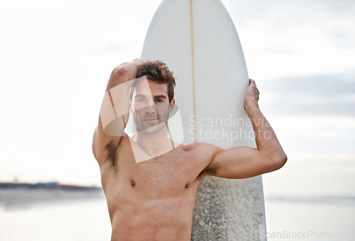 Image of Man, portrait and surfboard on beach for waves, exercise or outdoor hobby in fitness, surfing or practice. Active male person or surfer with board for training at seaside or ocean coast in nature