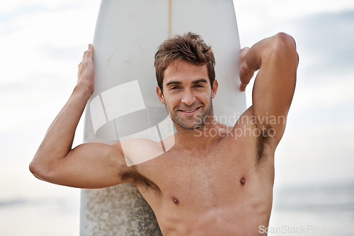 Image of Happy man, portrait and surfboard on beach for waves, exercise or outdoor hobby in fitness, surfing or practice. Active male person or surfer with board for training, seaside or ocean coast in nature
