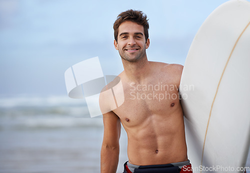 Image of Happy man, portrait and surfboard on beach for waves, exercise or fitness in outdoor hobby, surfing or practice. Active male person or surfer smile with board for training, seaside or ocean coast
